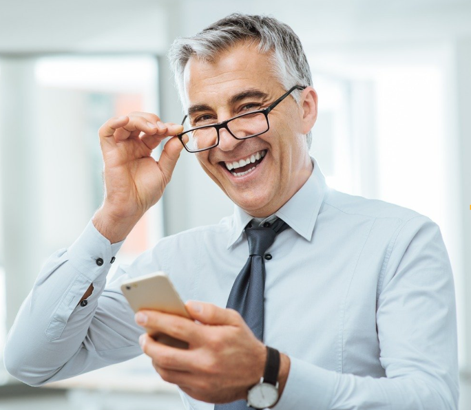Business owner smiling while checking phone reviews